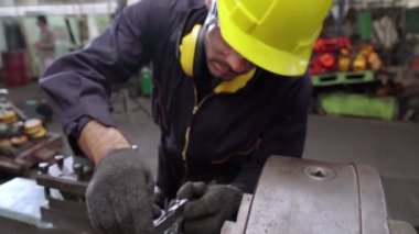 Fabrika atölyesinde makine kullanan akıllı bir fabrika işçisi