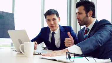 İki iş adamı ofiste proje stratejisi hakkında konuşuyor