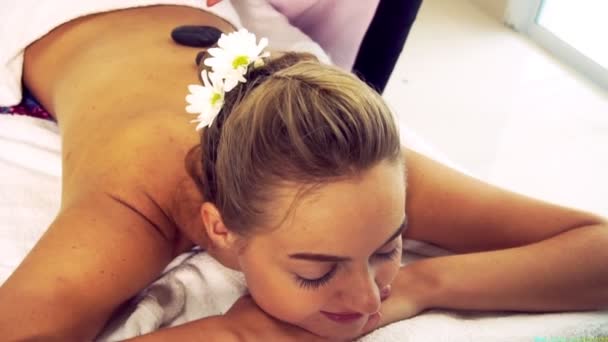 Hot stone massage treatment by therapist in spa. — Stock Video