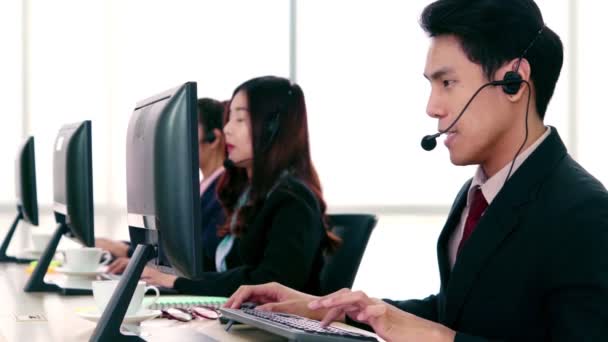 Uomini d'affari che indossano cuffie che lavorano in ufficio — Video Stock