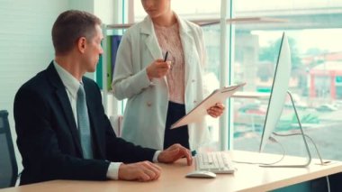 İki iş adamı ofiste proje stratejisi hakkında konuşuyor