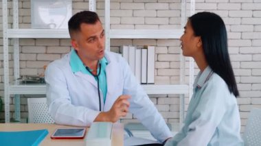 Profesyonel üniformalı doktor hastanedeki hastayı muayene ediyor.