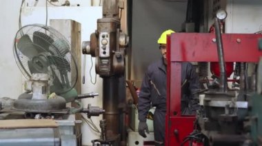 Genç bir fabrika işçisi ya da mühendis fabrikada portreyi kapatıyor.