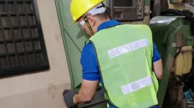 Fabrika atölyesinde makine kullanan akıllı bir fabrika işçisi