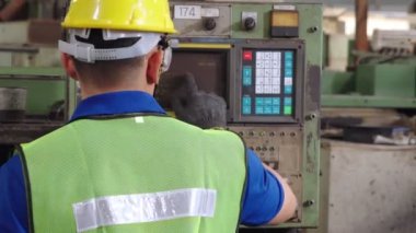 Fabrika atölyesinde makine ekipmanı kullanan bir grup işçi.