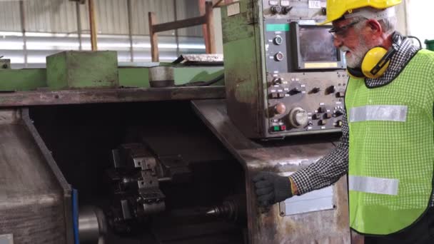 Starszy pracownik fabryki uczy obsługi urządzeń maszynowych w fabryce — Wideo stockowe