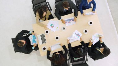 İş adamları grup toplantısı ofiste yukarıdan çekildi. İş kadınları, iş adamları ve ofis çalışanları, proje planlama belgeleriyle takım konferansında toplantı masasında çalışıyorlar. .