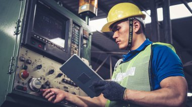 Fabrika atölyesinde makine kullanan akıllı bir fabrika işçisi. Endüstri ve mühendislik kavramı.
