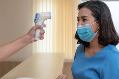 Ofiste ya da hastanede konuşurken resepsiyonist ve misafir maske takıyor. Covid 19 ve Coronavirus enfeksiyon koruması ve koruma politikası kavramı .