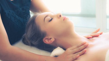 Profesyonel masaj terapisti tarafından masaj yaptıran rahat bir kadın. Sağlık, şifa ve rahatlama konsepti.