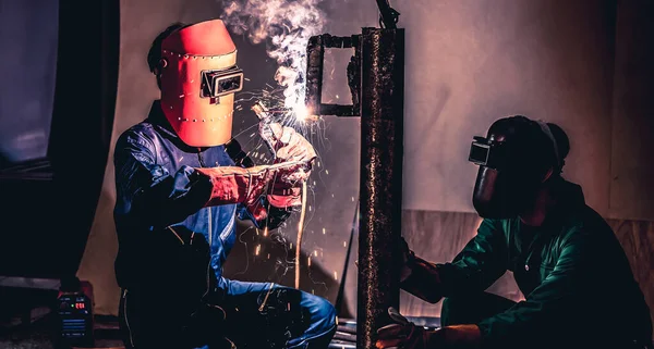 Metal welding steel works using electric arc welding machine to weld steel at factory. Metalwork manufacturing and construction maintenance service by manual skill labor concept.