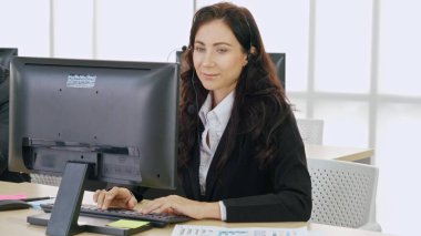 Ofiste çalışan kulaklık takan işadamları uzak müşteri ya da meslektaşlarını desteklemek için çalışıyorlar. Arama merkezi, tele pazarlama, müşteri destek acentesi telefon görüşmesinde hizmet sunar.