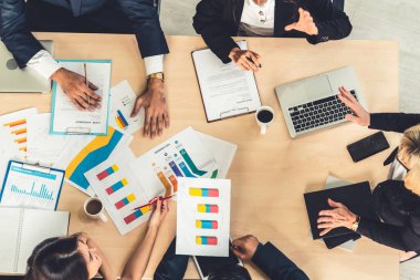 İş adamları grup toplantısı ofiste yukarıdan çekildi. İş kadınları, iş adamları ve ofis çalışanları, proje planlama belgeleriyle takım konferansında toplantı masasında çalışıyorlar. .