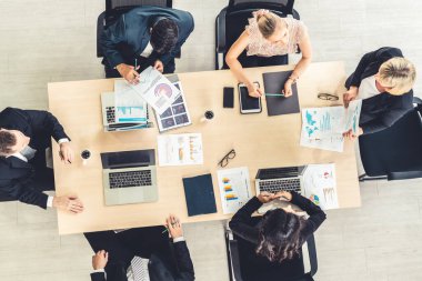 İş adamları grup toplantısı ofiste yukarıdan çekildi. İş kadınları, iş adamları ve ofis çalışanları, proje planlama belgeleriyle takım konferansında toplantı masasında çalışıyorlar. .