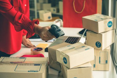 Çevrimiçi satıcı ev ofisinde çalışıyor ve teslimat kutusunu müşteriye paketliyor. İnternette e-ticaret yapan küçük işletme sahibi ya da girişimci.