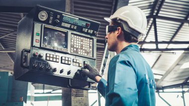 Fabrika atölyesinde makine kullanan akıllı bir fabrika işçisi. Endüstri ve mühendislik kavramı.