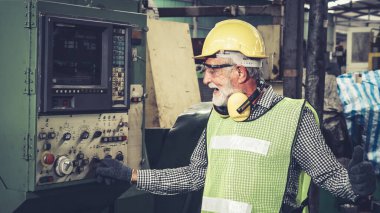 Fabrika atölyesinde makine kullanan akıllı bir fabrika işçisi. Endüstri ve mühendislik kavramı.