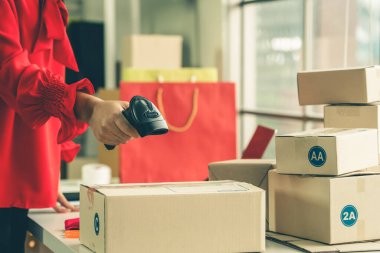 Çevrimiçi satıcı ev ofisinde çalışıyor ve teslimat kutusunu müşteriye paketliyor. İnternette e-ticaret yapan küçük işletme sahibi ya da girişimci.