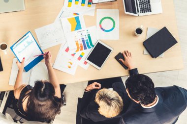 İş adamları grup toplantısı ofiste yukarıdan çekildi. İş kadınları, iş adamları ve ofis çalışanları, proje planlama belgeleriyle takım konferansında toplantı masasında çalışıyorlar. .