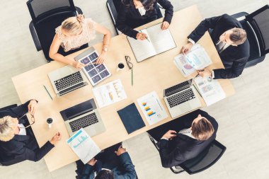 İş adamları grup toplantısı ofiste yukarıdan çekildi. İş kadınları, iş adamları ve ofis çalışanları, proje planlama belgeleriyle takım konferansında toplantı masasında çalışıyorlar. .