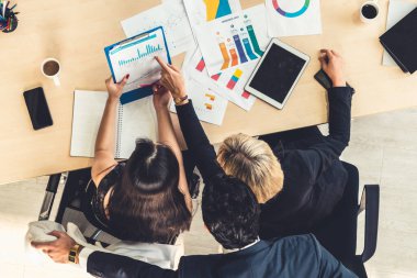 İş adamları grup toplantısı ofiste yukarıdan çekildi. İş kadınları, iş adamları ve ofis çalışanları, proje planlama belgeleriyle takım konferansında toplantı masasında çalışıyorlar. .