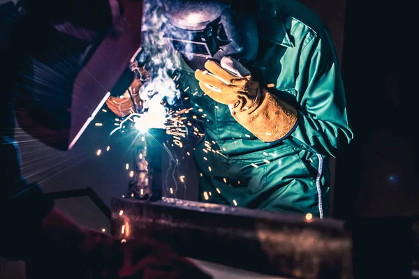 Metal welding steel works using electric arc welding machine to weld steel at factory. Metalwork manufacturing and construction maintenance service by manual skill labor concept.