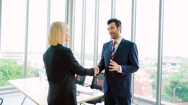 Business people handshake in corporate office showing professional agreement on a financial deal contract.