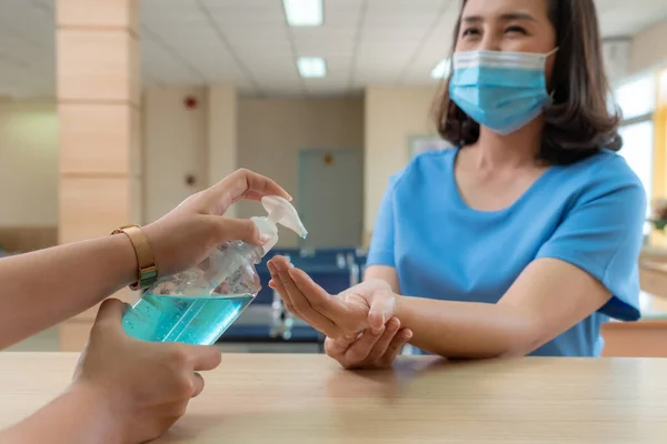 Receptionist and guest wearing face mask at front desk while having conversation in office or hospital . Covid 19 and coronavirus infection protection and protective policy concept .