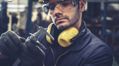 Fabrika atölyesinde makine kullanan akıllı bir fabrika işçisi. Endüstri ve mühendislik kavramı.