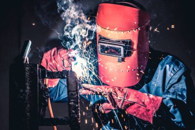 Metal welding steel works using electric arc welding machine to weld steel at factory. Metalwork manufacturing and construction maintenance service by manual skill labor concept. clipart