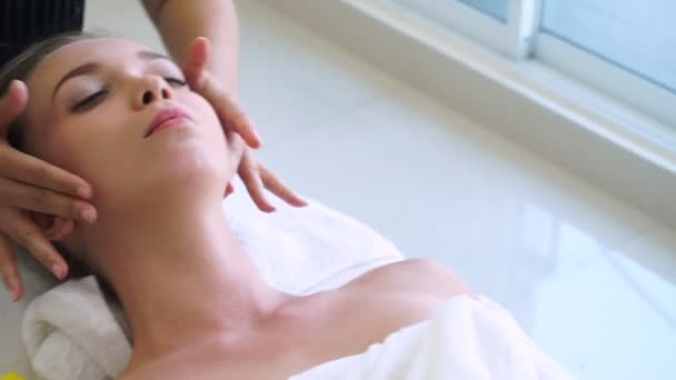 Femme se fait masser le visage et la tête dans un spa de luxe. — Video
