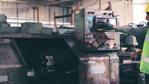 Старший работник завода обучает работе с машинным оборудованием в цехе завода — стоковое видео