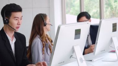 Ofiste çalışan kulaklık takan iş adamları.