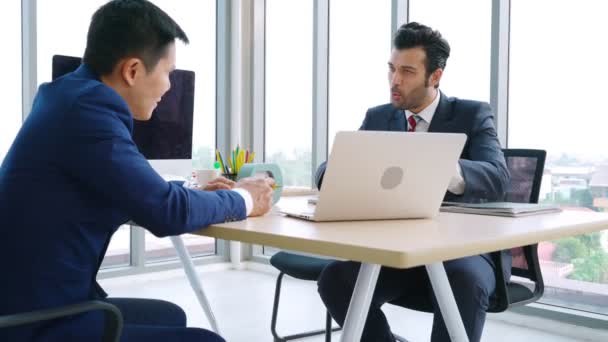 Két üzletember megbeszéli a projektstratégiát az irodában. — Stock videók