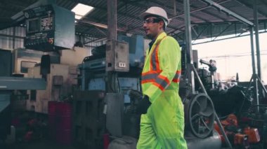 Fabrika işçileri fabrikadaki ekip üyeleriyle tokalaşıyor.