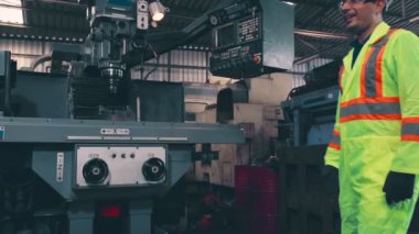 Fabrika işçileri fabrikadaki ekip üyeleriyle tokalaşıyor.