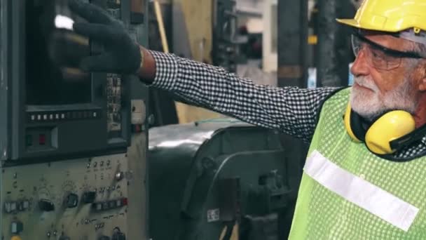 工場の先輩労働者が工場で機械設備の使い方を教えています — ストック動画