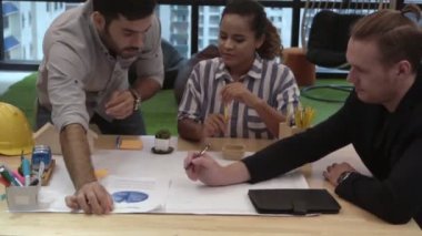 Yaratıcı iş adamları grubu iş yerindeki ofis masasında sohbet ediyorlar..