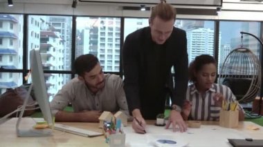 Yaratıcı iş adamları grubu iş yerindeki ofis masasında sohbet ediyorlar..