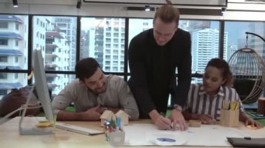 Yaratıcı iş adamları grubu iş yerindeki ofis masasında sohbet ediyorlar..