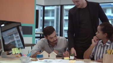 Yaratıcı iş adamları grubu iş yerindeki ofis masasında sohbet ediyorlar..