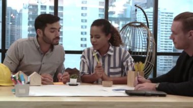 Yaratıcı iş adamları grubu iş yerindeki ofis masasında sohbet ediyorlar..