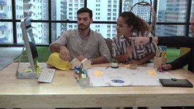 Yaratıcı iş adamları grubu iş yerindeki ofis masasında sohbet ediyorlar..