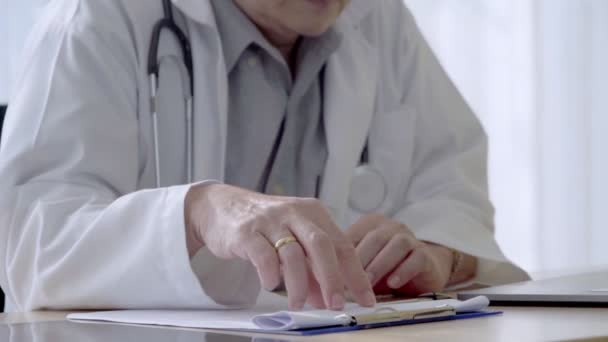 Лікар, який працює з даними про стан здоров'я пацієнта в лікарні . — стокове відео