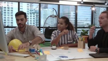 Yaratıcı iş adamları grubu iş yerindeki ofis masasında sohbet ediyorlar..