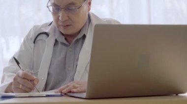 Hastane ofisinde hasta sağlığı verileriyle çalışan bir doktor..
