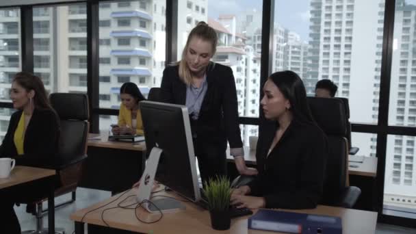 Jonge leider geeft advies aan jonge vrouwelijke werknemer. — Stockvideo