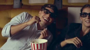 Sinemada erkek ve kadın 3 boyutlu film izliyor.