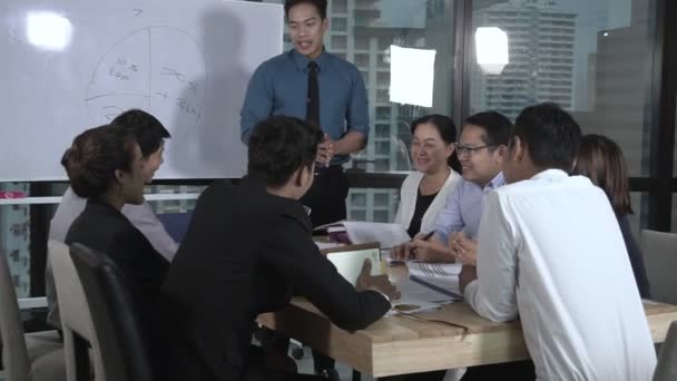 Asian business people discuss marketing strategy.