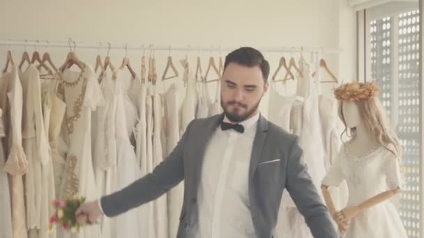 Lustiger Bräutigam in Hochzeitskleidung tanzt in Garderobe. — Stockvideo